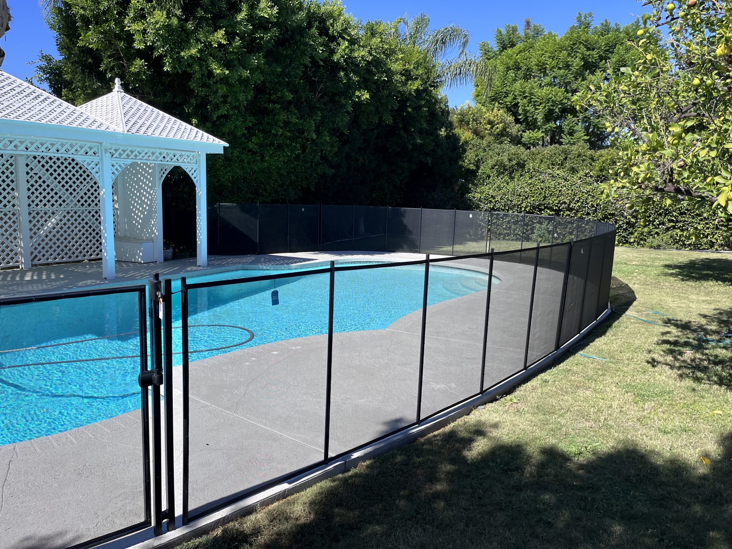 Installed mesh pool fence around a backyard pool